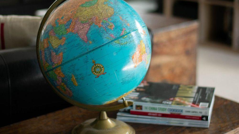 Foto von einem Globus und Reisebücher auf einem Tisch